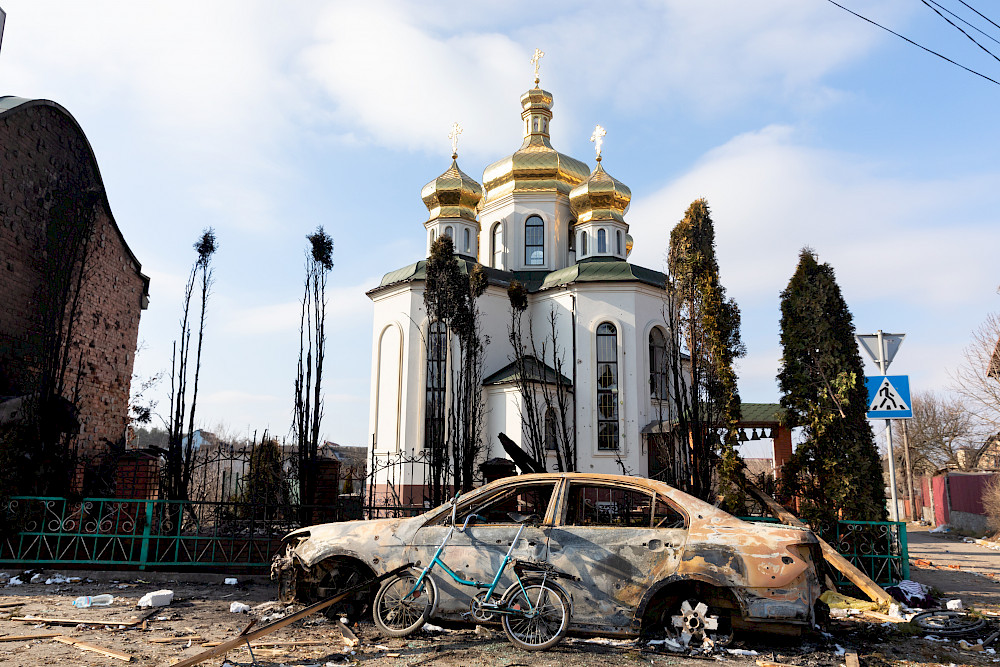 Eine beschädigte Kirche und ein verbranntes Auto am Rande von Irpin (Ukraine).