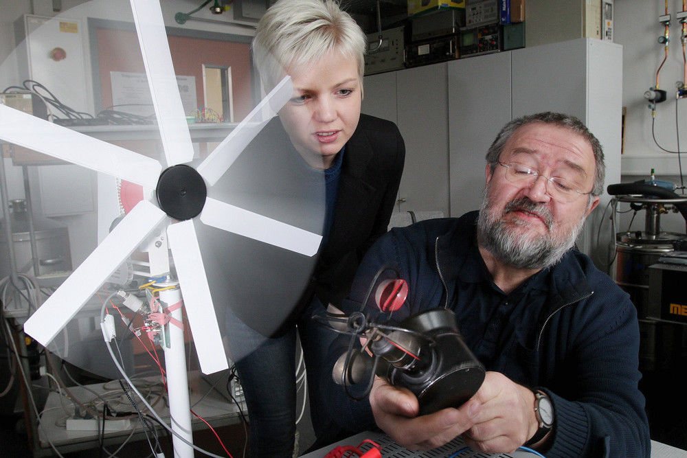 Kristin Suckau und Dr. Ulrich Straube messen mit einem Windmesser die Strömungsgeschwindigkeit, die vom Windrad-Modell erzeugt wird.