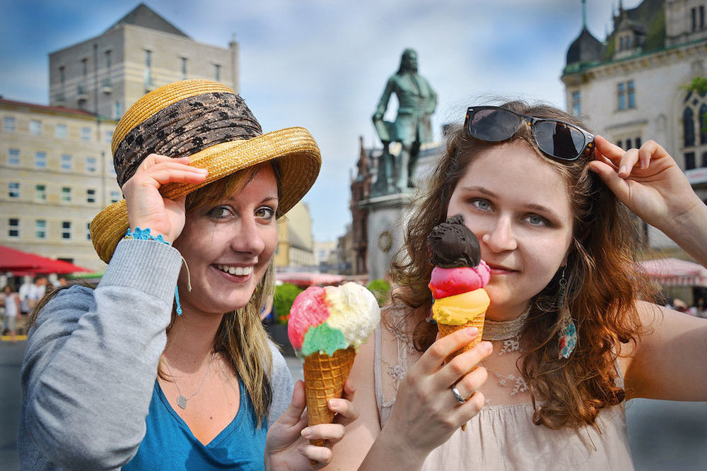 Diana Righi und Luise Vorwerk gönnen sich auf dem halleschen Marktplatz ein italienisches Eis 