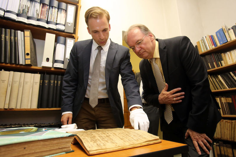 Archivar Michael Ruprecht zeigt Ministerpräsident Reiner Haseloff (v.l.) die Matrikelbände der Universität.