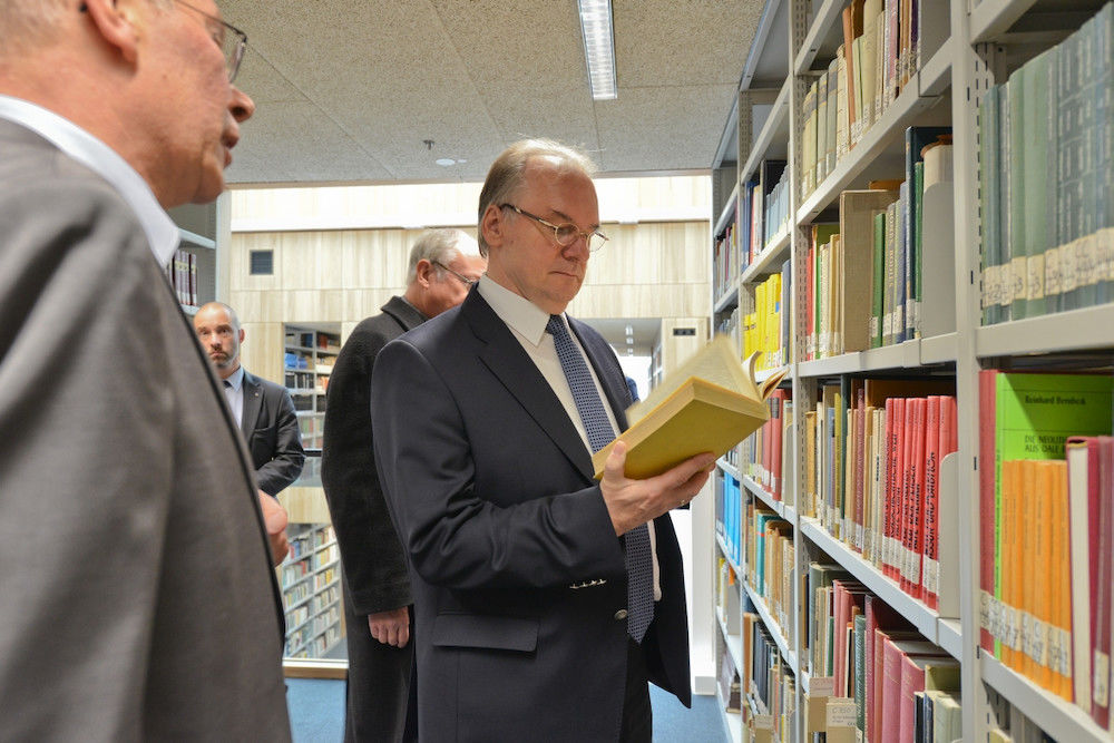Der Ministerpräsident  lässt sich durch die neue Bibliothek führen. 