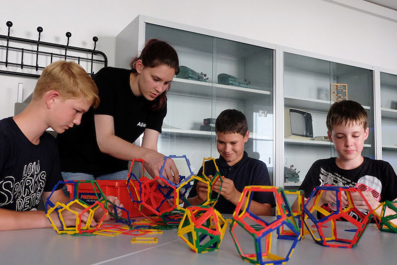 Mathe als Freizeitbeschäftigung: Gemeinsam mit den Studierenden bauen die Schüler geometrische Körper.
