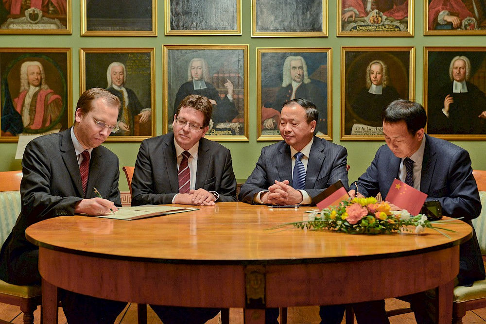 Während der Unterzeichnung des Memorandums: Christoph Kumpan, Rektor Christian Tietje, Uni-Präsident Zitang Fu und Meisong Guo (v.l.)