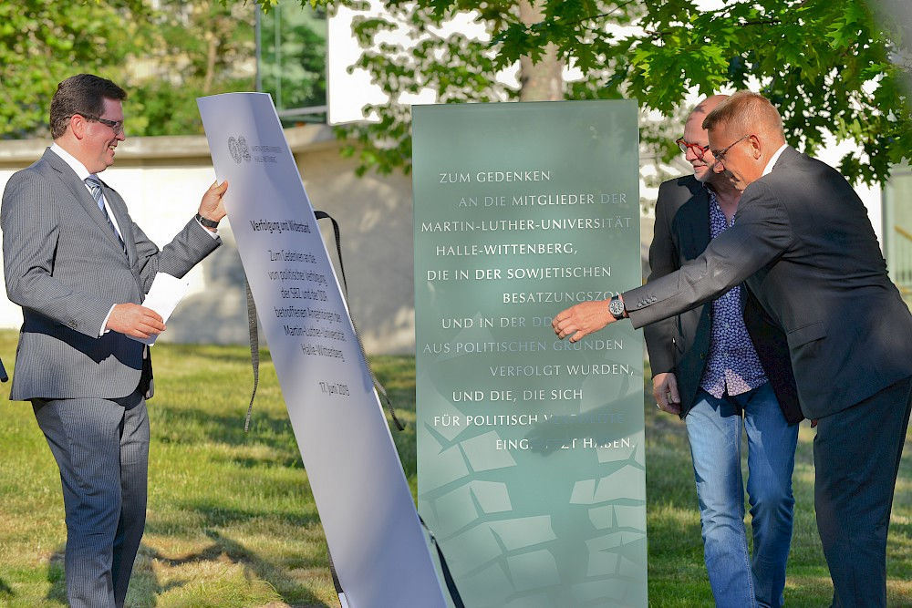 Rektor Christian Tietje, Künstler Joachim Dimanski und Friedemann Stengel (v.li.)  bei der Enthüllung der Stele