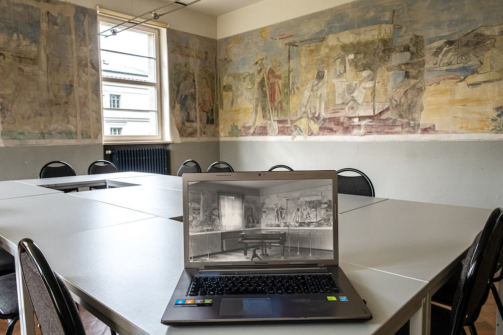 Charles Crodels Wandmalereien im Musikzimmer der Burse zur Tulpe – und eine historische Aufnahme auf dem Laptop.