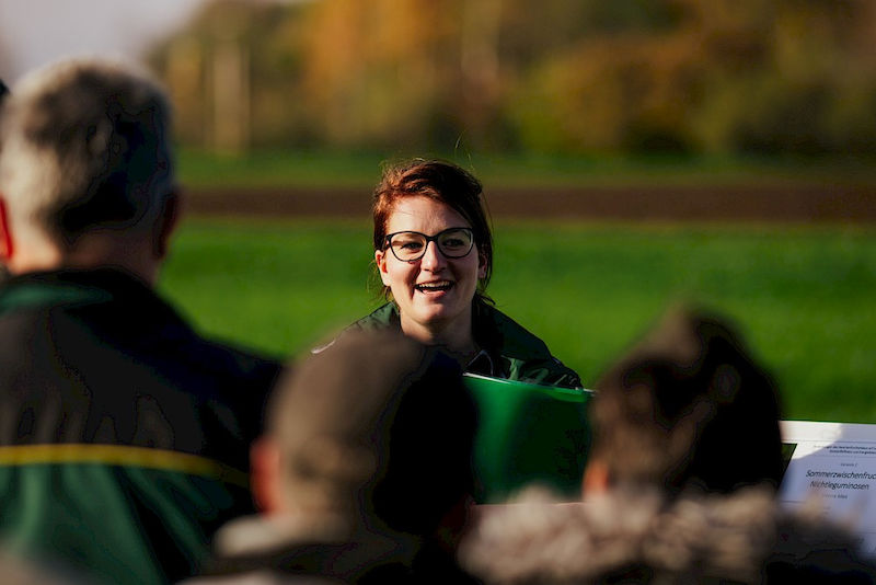 Paula Fuchs stellt auf einem Feldtag Landwirten die Vorteile der Zwischenfrüchte vor.