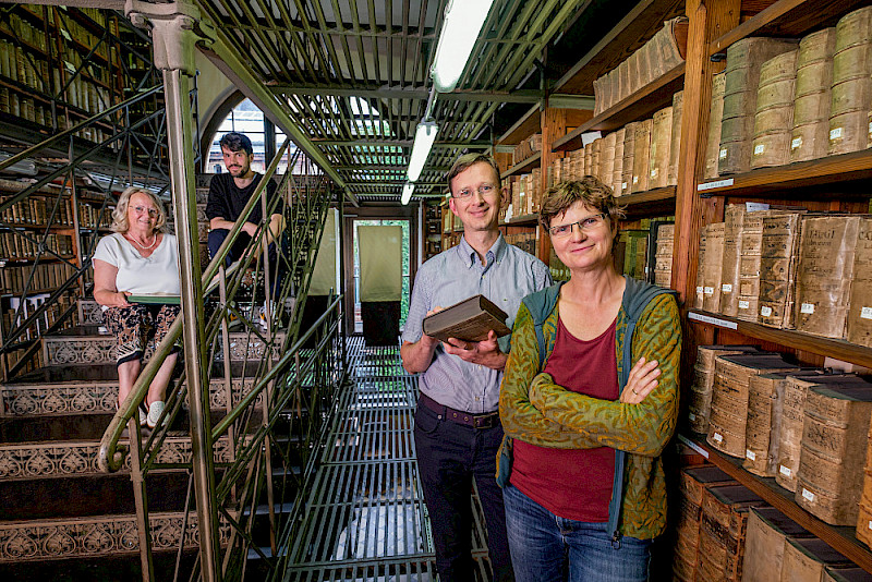 Citizen scientist Isa Brähler, doctoral student Moritz Müller, citizen scientist Joachim Hassel and project manager Katrin Moeller (from left to right) in the library of St. Mary’s Church where the original church records are kept.
