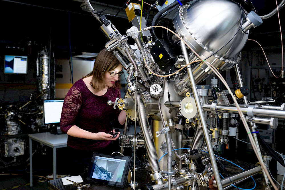 Doctoral candidate Philine Stötzner works on the high vacuum system.