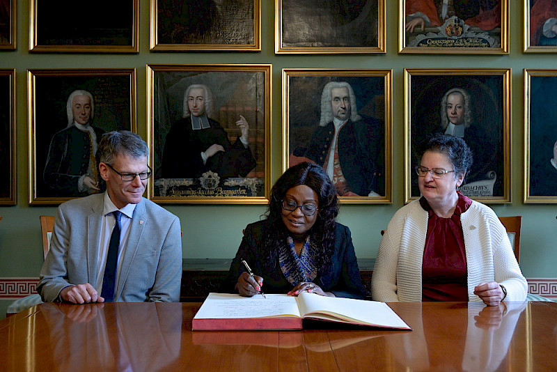 Gina Ama Blay (Mitte) trug sich in Anwesenheit von Bürgermeister Egbert Geier und Rektorin Claudia Becker ins Goldene Buch der Universität ein.