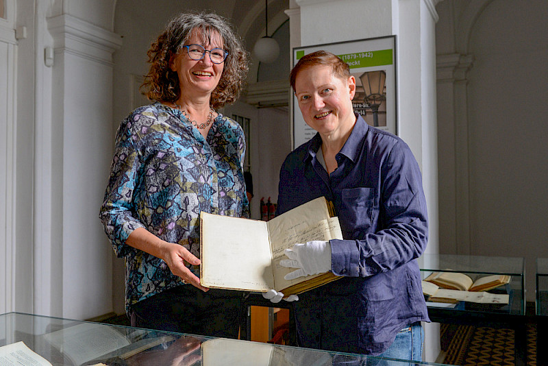 Die Germanistin Andrea Seidel (links) und Julia Knödler von der ULB präsentieren eines der "Hallischen Schöffenbücher" aus dem 13. Jahrhundert, mit denen Agathe Lasch in Hamburg gearbeitet hat.