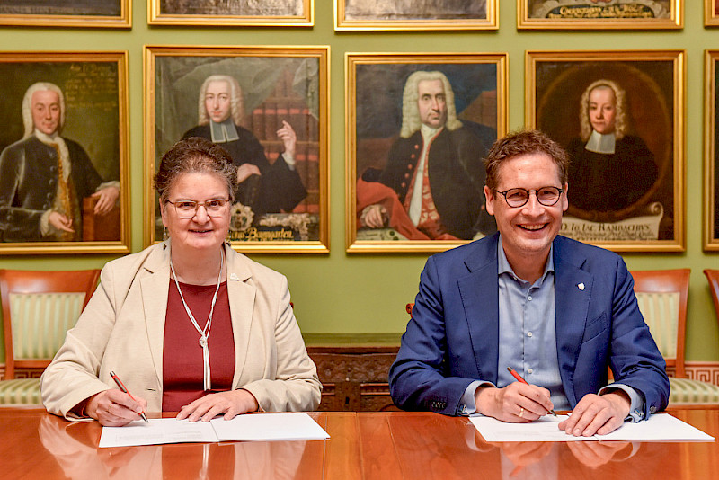 Rektorin Claudia Becker und Oberbürgermeister Alexander Vogt bei der Unterzeichnung des neuen Maßnahmenplans